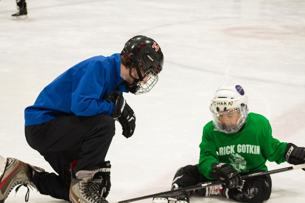 A camper reaching down to help a teammate who has gone down