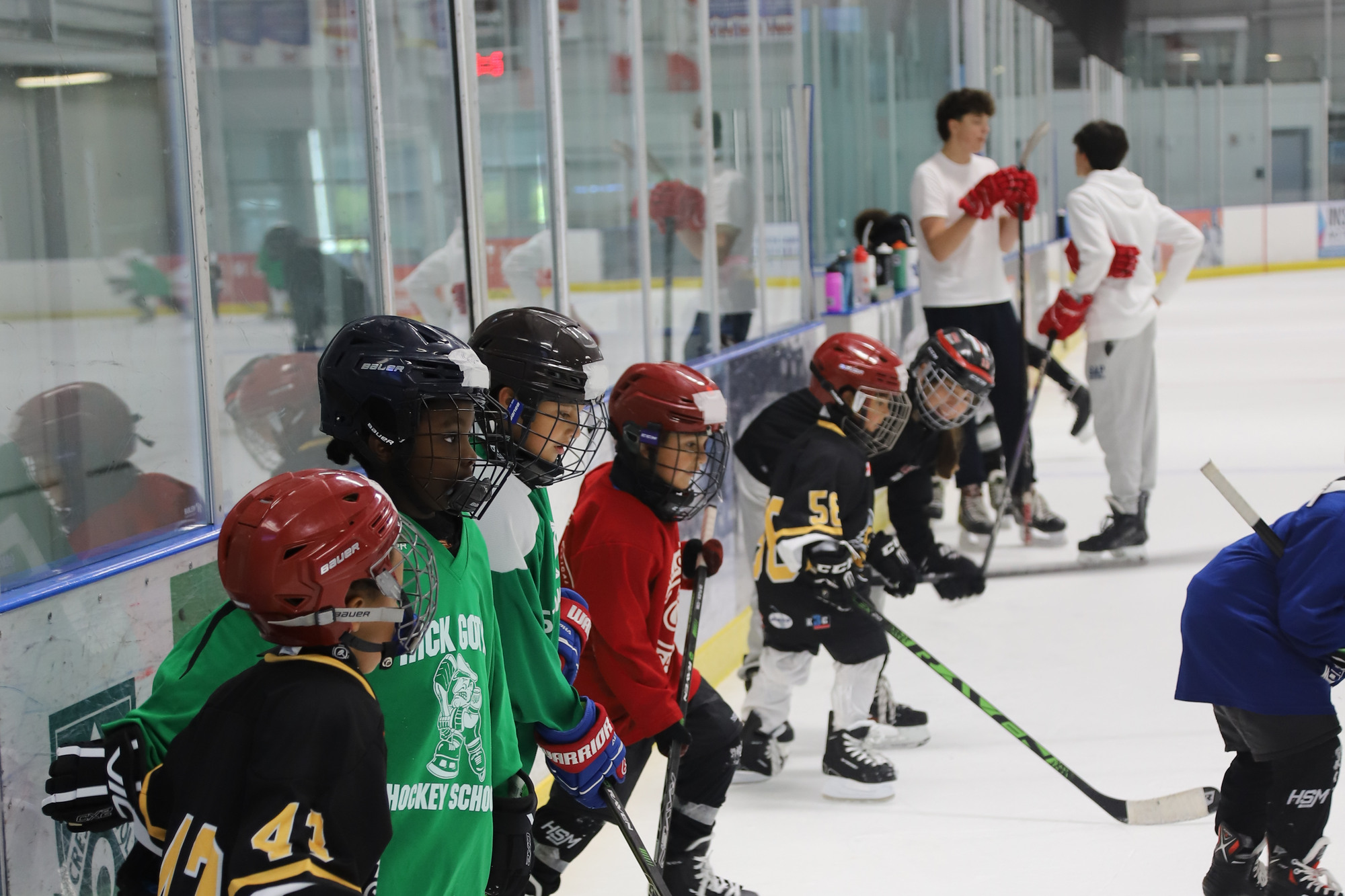 Campers lined up along the boards with their sticks, waiting their turn at a drill