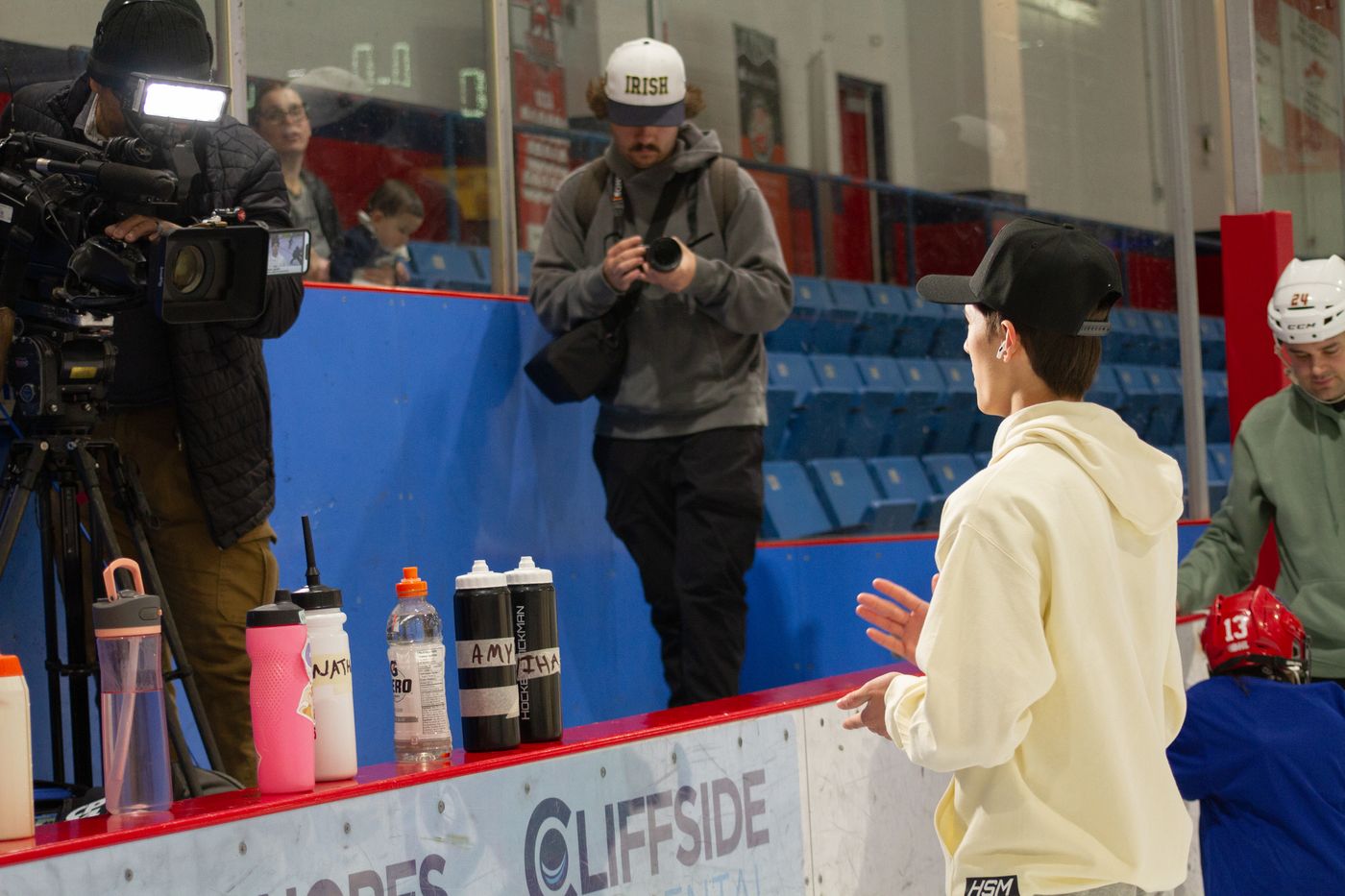A television camera operator filming on the arena walkway during media day at the camp