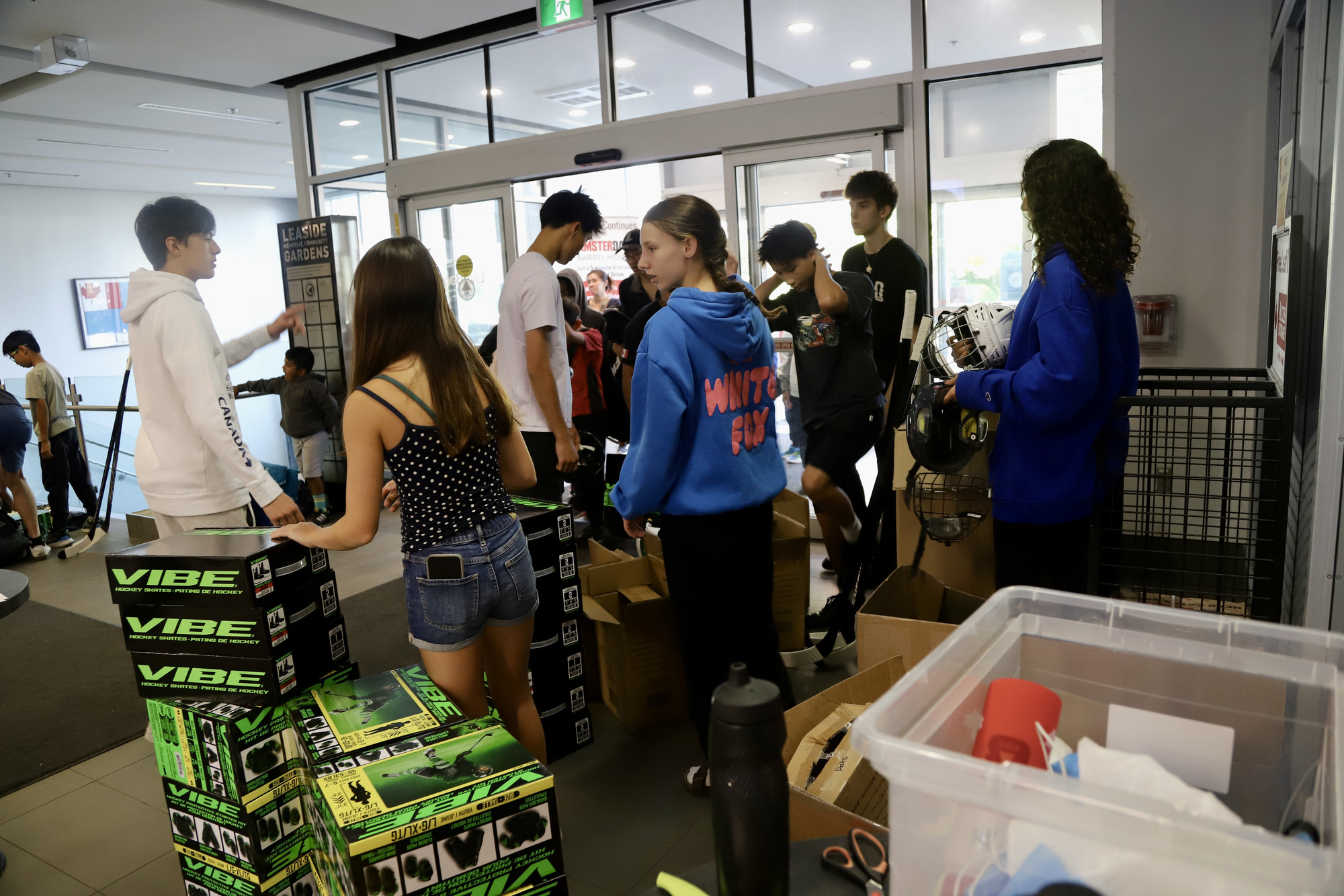 Volunteers working through boxes and helmets in the arena lobby